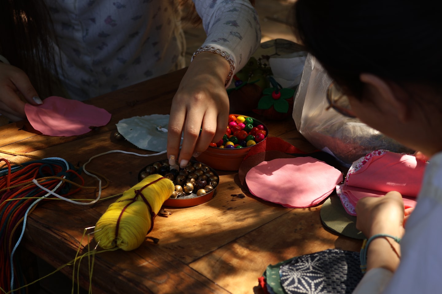 People working together on craft projects at a wooden table.
